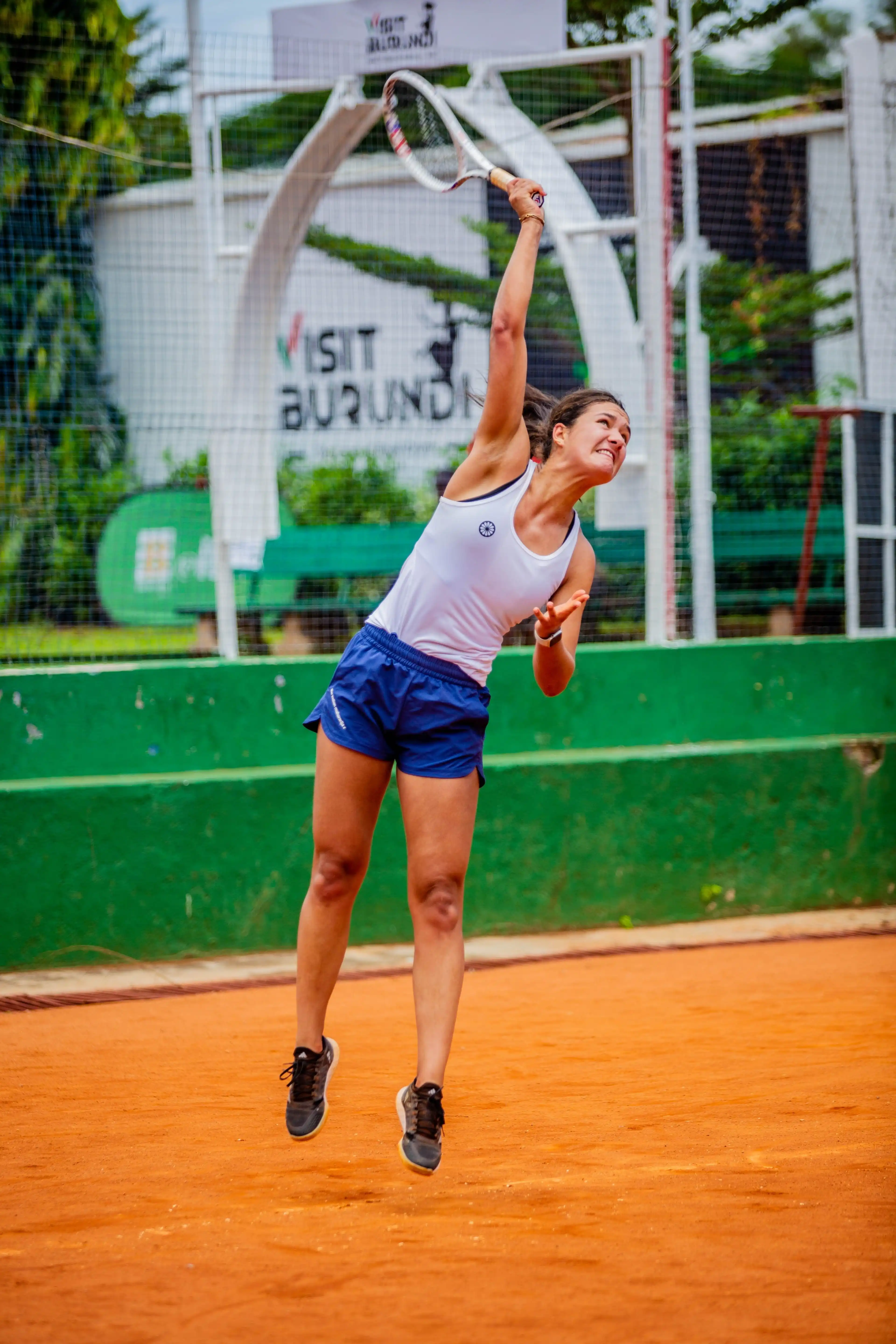 Tennis player serving on a clay court